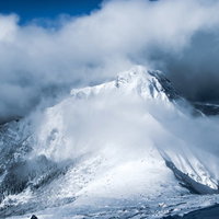 降雪直後の阿弥陀岳、雲に覆われた雪化粧の山頂の写真