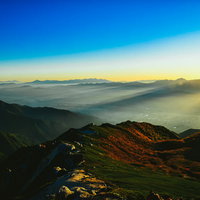 降り注ぐ天使の梯子と朝靄の山の尾根から流れ込む光芒の写真