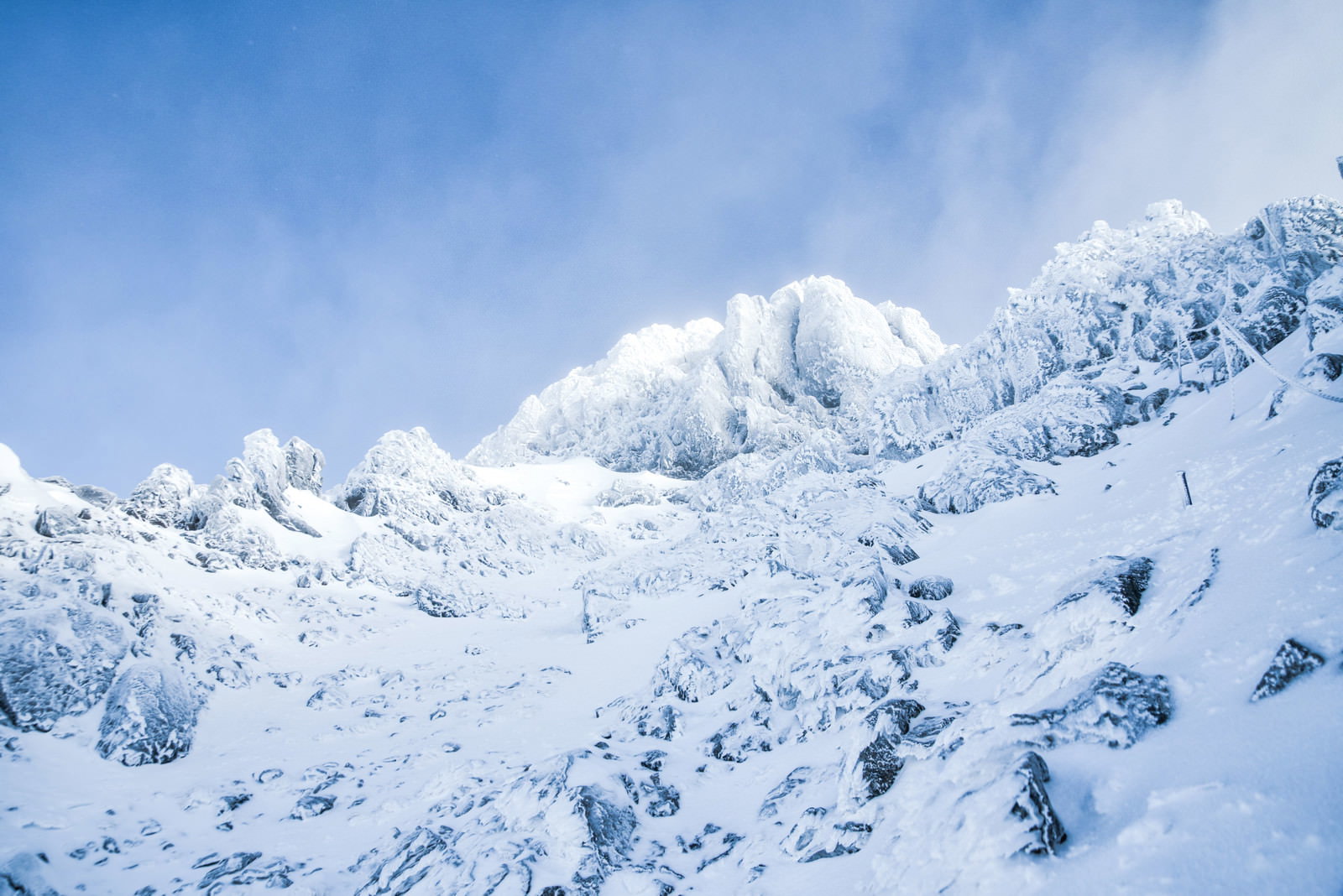 Winter mountain scenery of the snow-covered Yatsugatake Mountains' Akadake peak, viewed from the Bunjiro Ridge