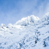 文三郎尾根から見上げた積雪した赤岳山頂（八ヶ岳連峰）の写真