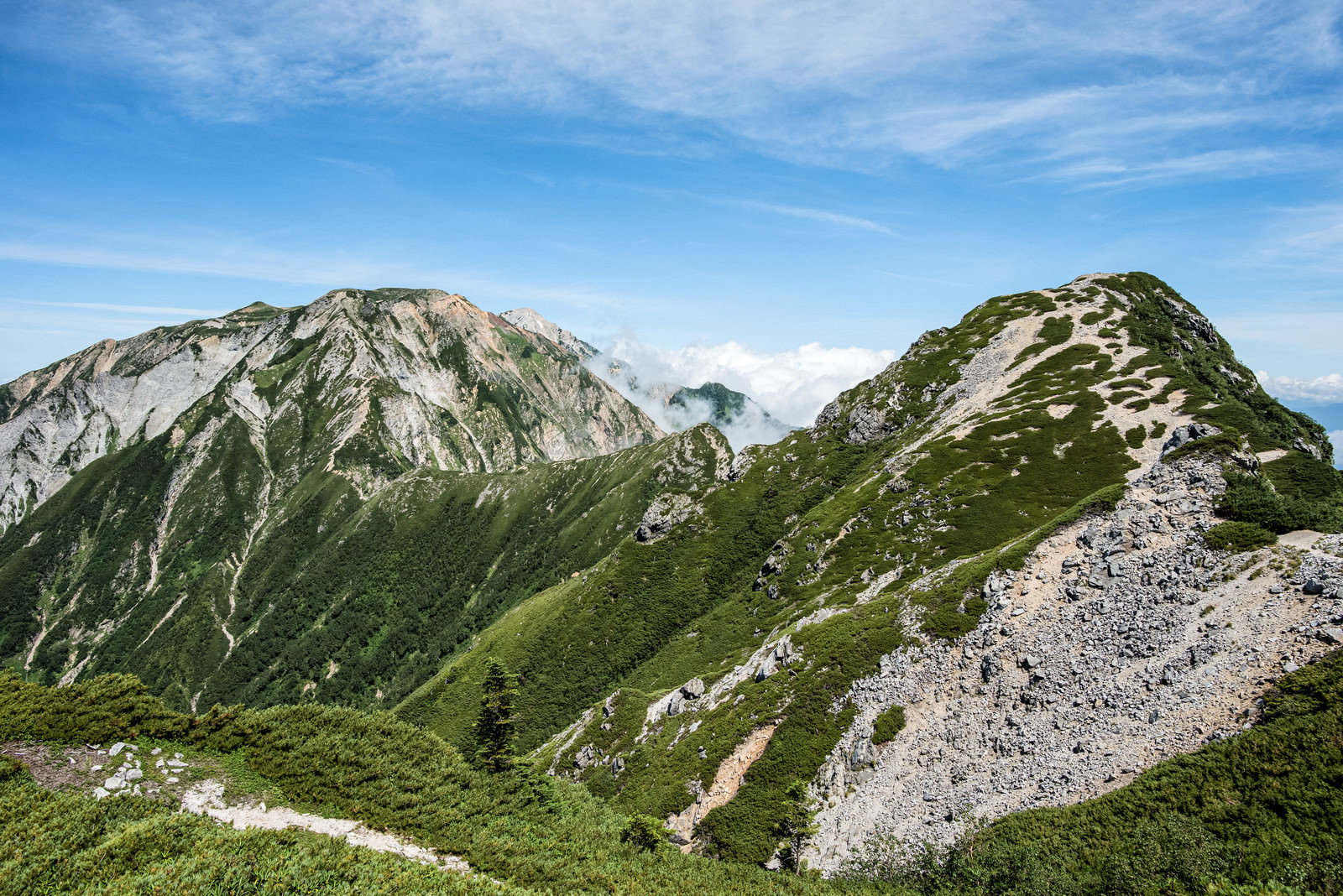 不帰キレットの険しい岩稜帯を進む登山道と青空