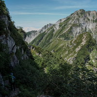 不帰キレット2峰直下の高度感のある巻道を歩く登山者の写真