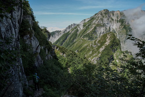 不帰キレット2峰直下の高度感のある巻道を歩く登山者