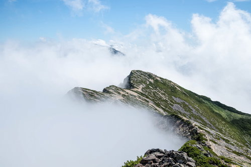 ガスに包まれ始める天狗背稜の険しい岩稜線