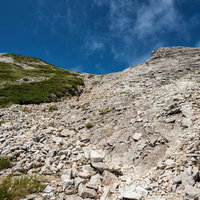 不帰キレットの天狗の大下り、白い石灰岩のザレ場が広がる急斜面の写真