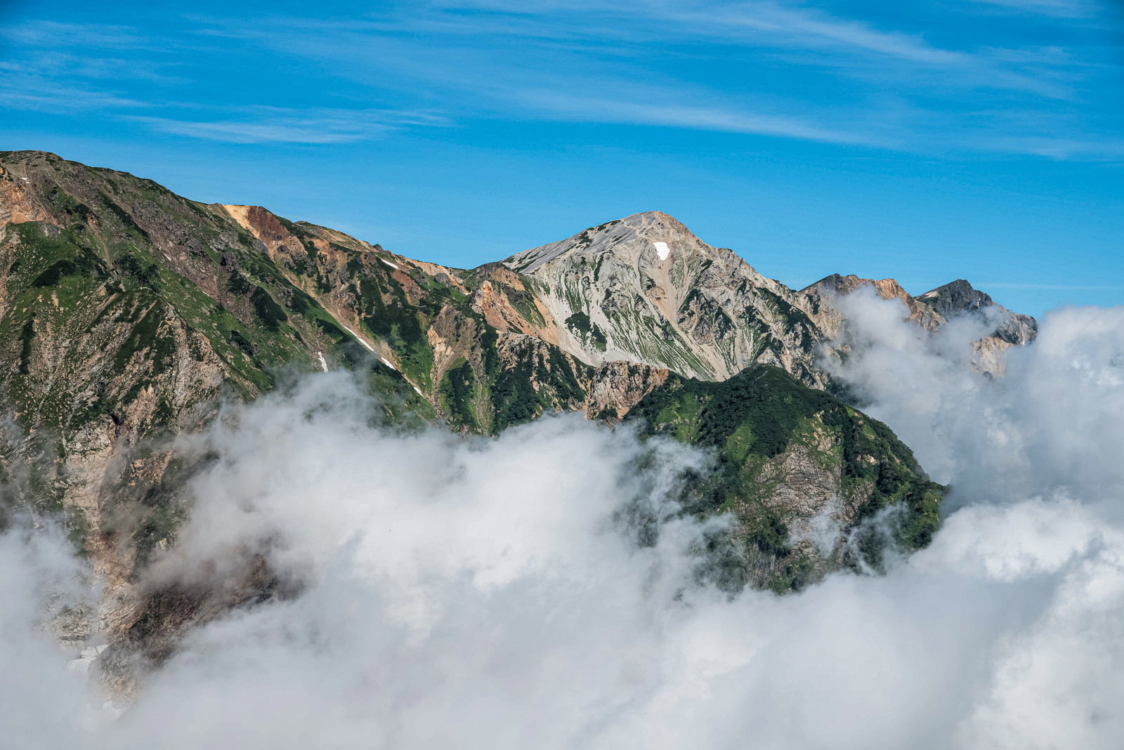 雲海に包まれた山々の中に白馬鑓ヶ岳が見える風景