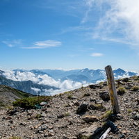天狗の頭の標識とキレット縦走の登山道を行く登山者の風景の写真