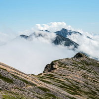 キレット縦走の天狗背稜と唐松岳の雲海に浮かぶ岩稜の写真