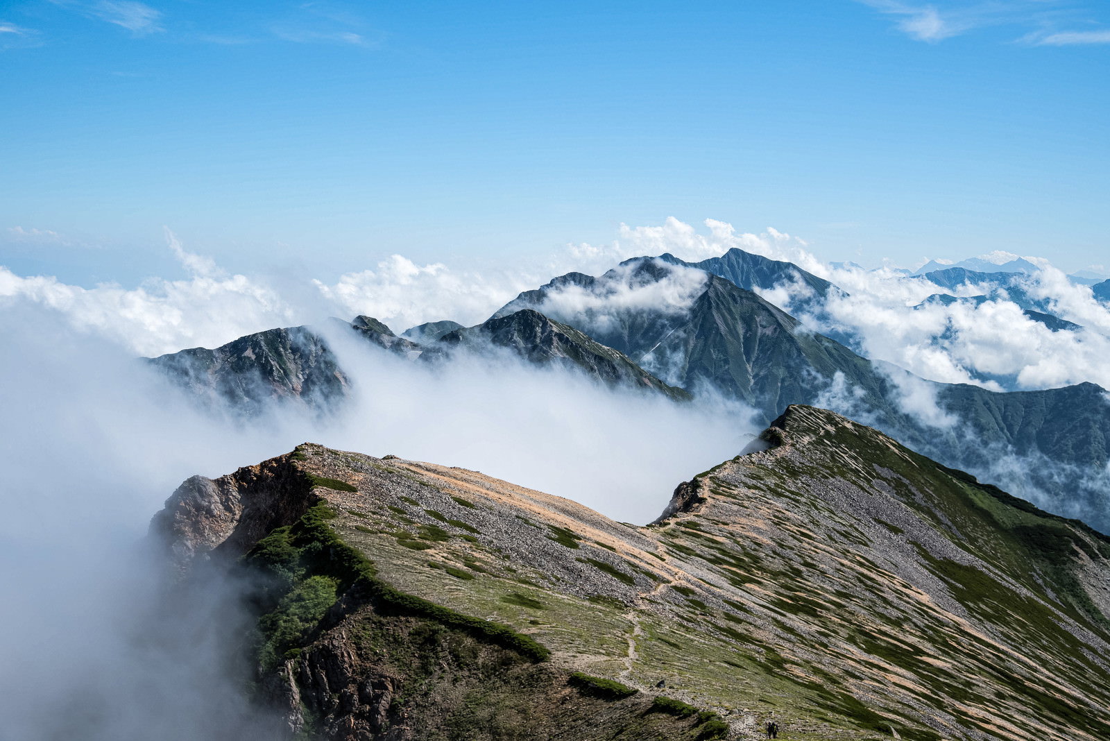雲海に浮かぶ不帰キレットと天狗背稜の山岳風景