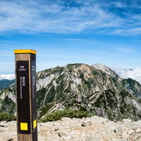 キレット縦走を経て唐松岳山頂に立つ登山指導標の写真