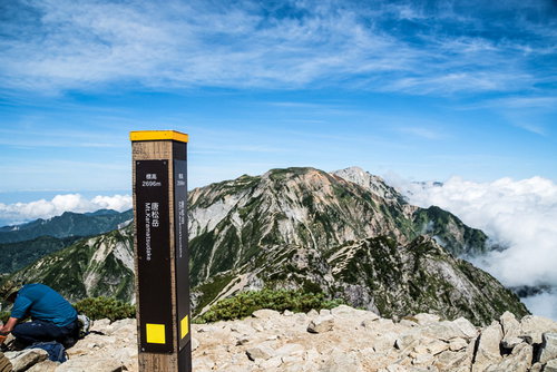 キレット縦走を経て唐松岳山頂に立つ登山指導標