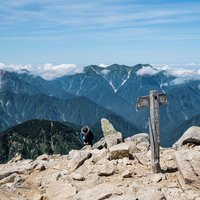 唐松岳山頂の指導標と北アルプスの雪山景色の写真
