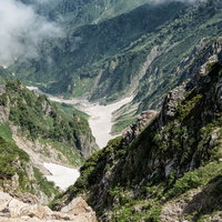 唐松岳のキレット縦走で見る唐松沢の残雪と岩場の写真