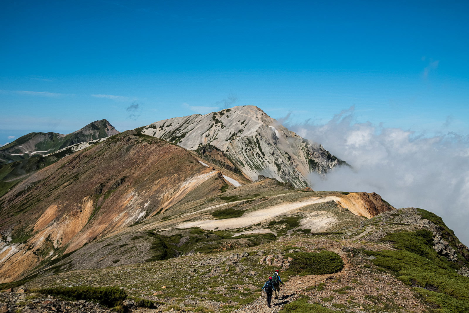 白馬鑓ヶ岳へと続く険しい岩稜帯の登山道を歩く登山者