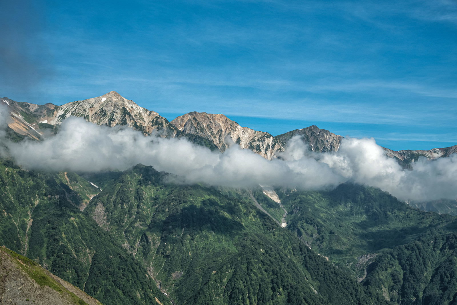 八方池から眺める雲に包まれた白馬三山の山岳風景