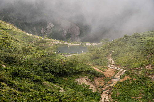 霧に包まれる八方池と不帰キレット、登山道の風景