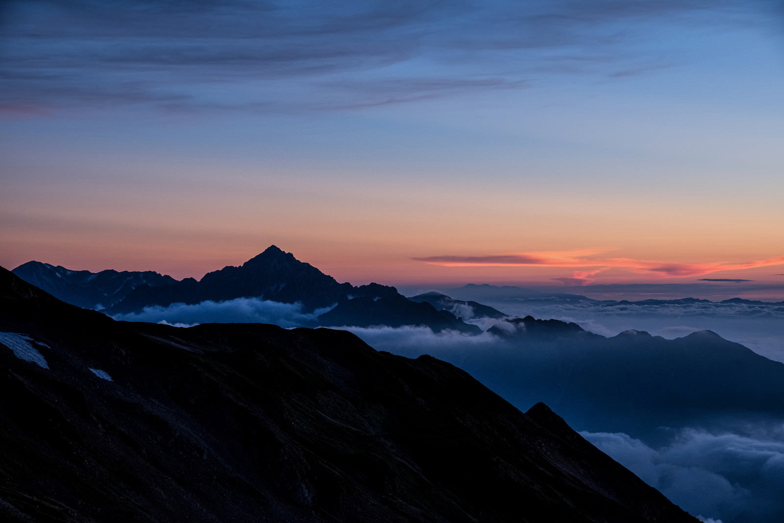夕焼け空をバックに剱岳のシルエットが浮かび上がる山岳風景