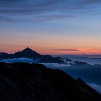 キレット縦走時の黄昏時、夕焼けに染まる剱岳のシルエットの写真