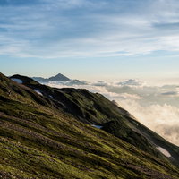 夕焼けに染まり始める剱岳の稜線とキレット縦走路の写真
