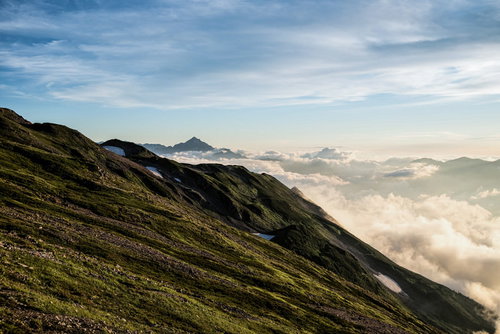 夕焼けに染まり始める剱岳の稜線とキレット縦走路