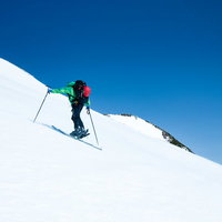 雪山の急斜面を登る山スキーヤーの登頂風景の写真