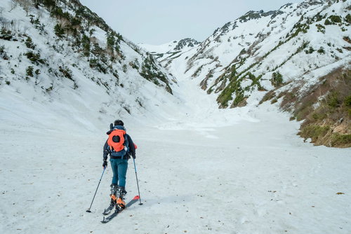 雪山の雪原を進む山スキーヤー