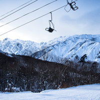 五竜岳を背景にしたスキー場のリフトと雪山風景の写真