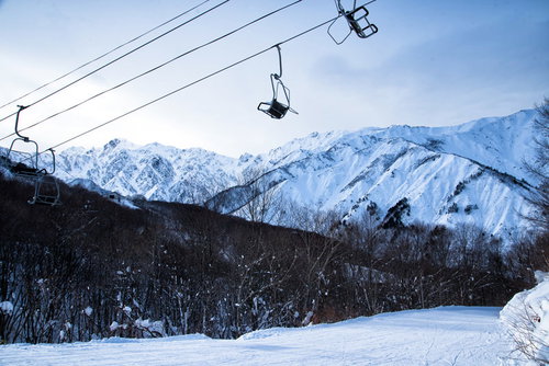 五竜岳を背景にしたスキー場のリフトと雪山風景