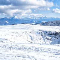 白銀に包まれた美ヶ原高原の雪原と遠景の雪山の写真