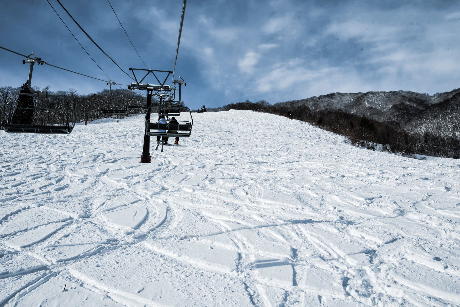 白馬五竜スキー場の未圧雪斜面に刻まれたシュプールとリフト