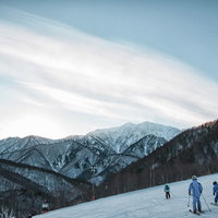 スキー場の上に現れた層雲とスキーヤーが滑る景色の写真