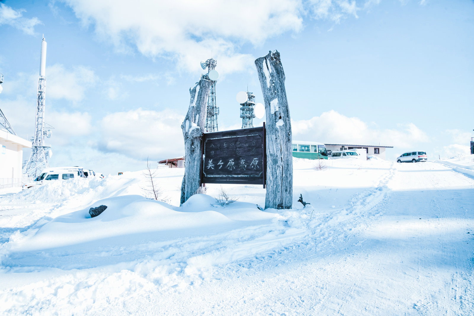 雪に覆われた美ヶ原高原に立つ青い看板と青空