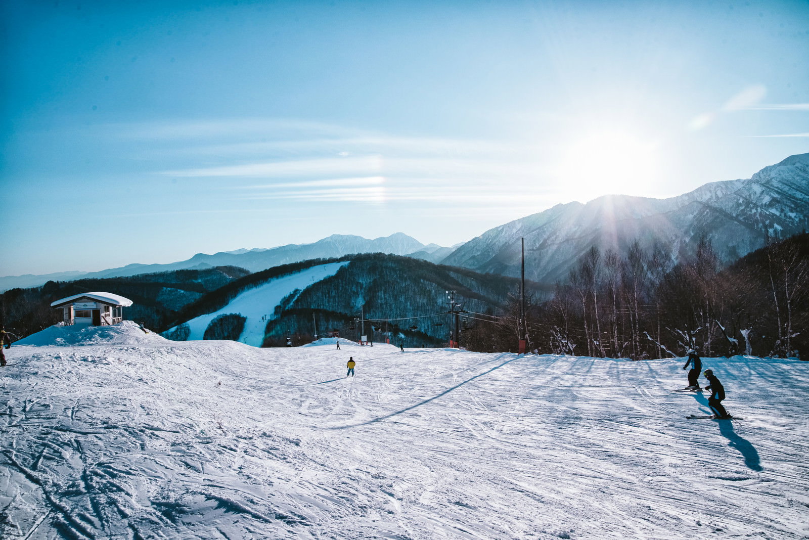 太陽の周りに暈が現れた雪山のスキー場ゲレンデ