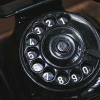 黒電話の円形ダイヤルをクローズアップしたの写真