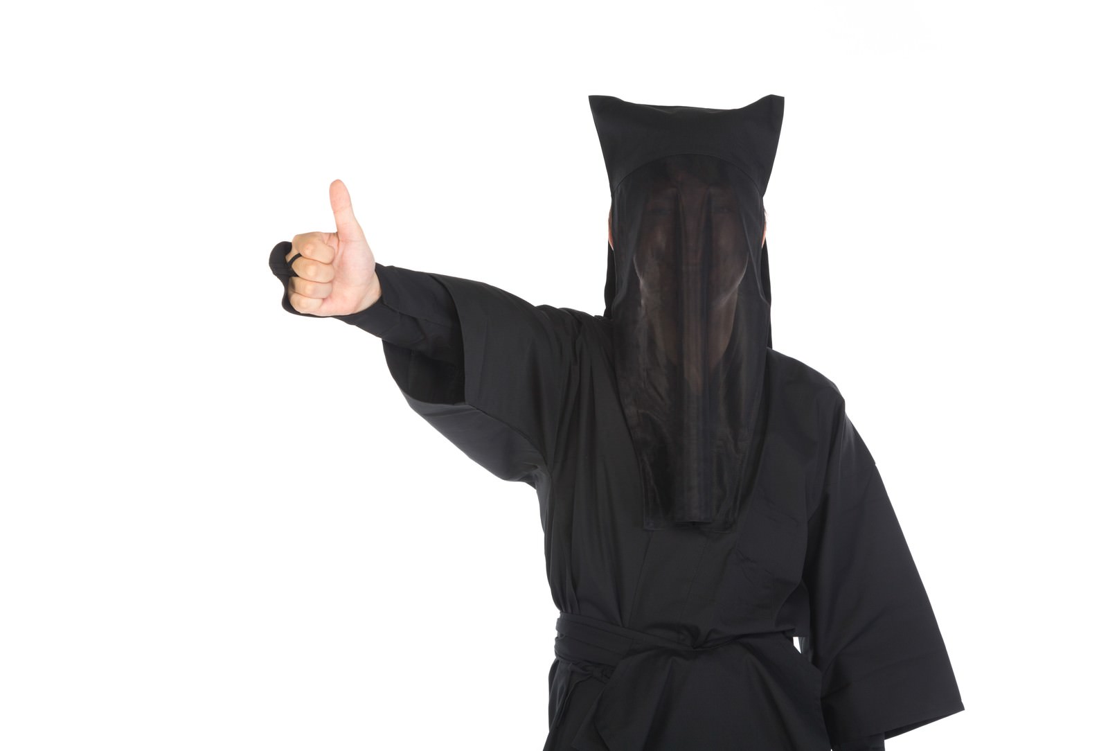黒い頭巾で顔を隠した人物が親指を立てるサムズアップポーズをしている［モデル：鈴木秀］