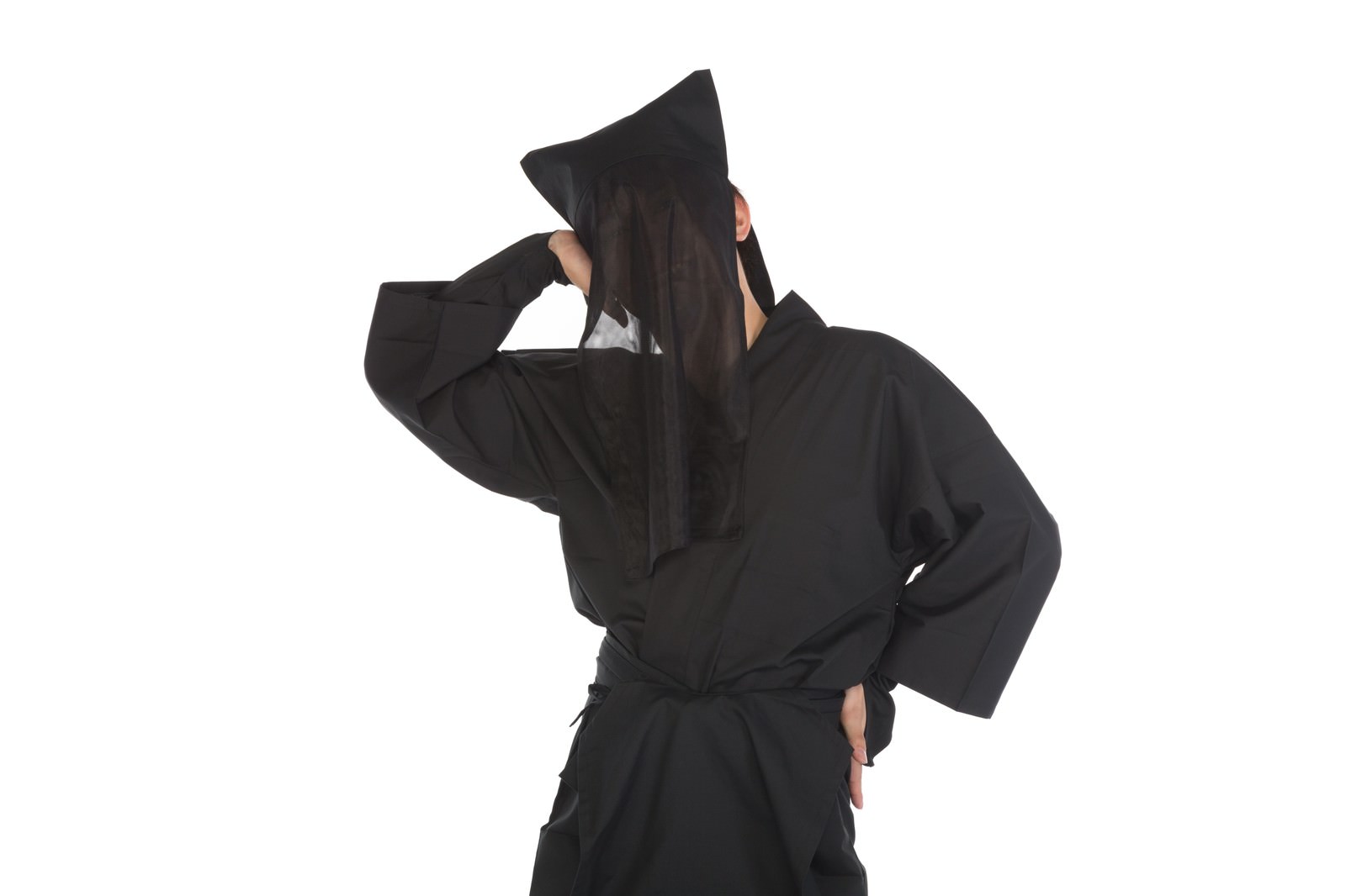 白い背景の前で黒い衣装を着た人物が、くねくねとしたポーズで頭を片手で抱えている［モデル：鈴木秀］