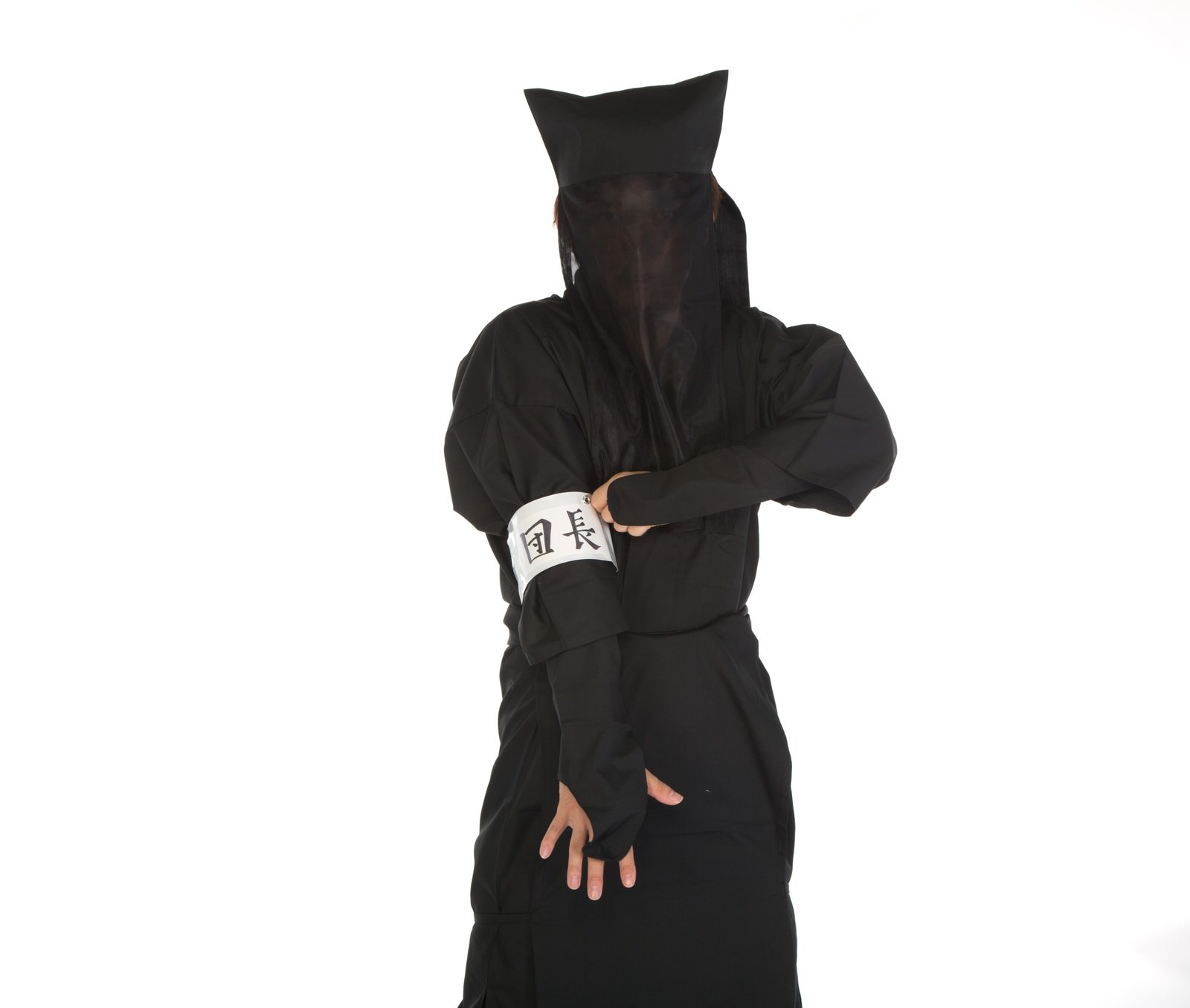 白い腕章をつけた黒装束の人物が白背景に立っている［モデル：鈴木秀］