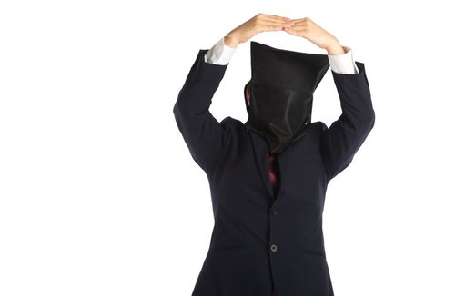 頭上でオッケーサインを作る黒いスーツ姿の人