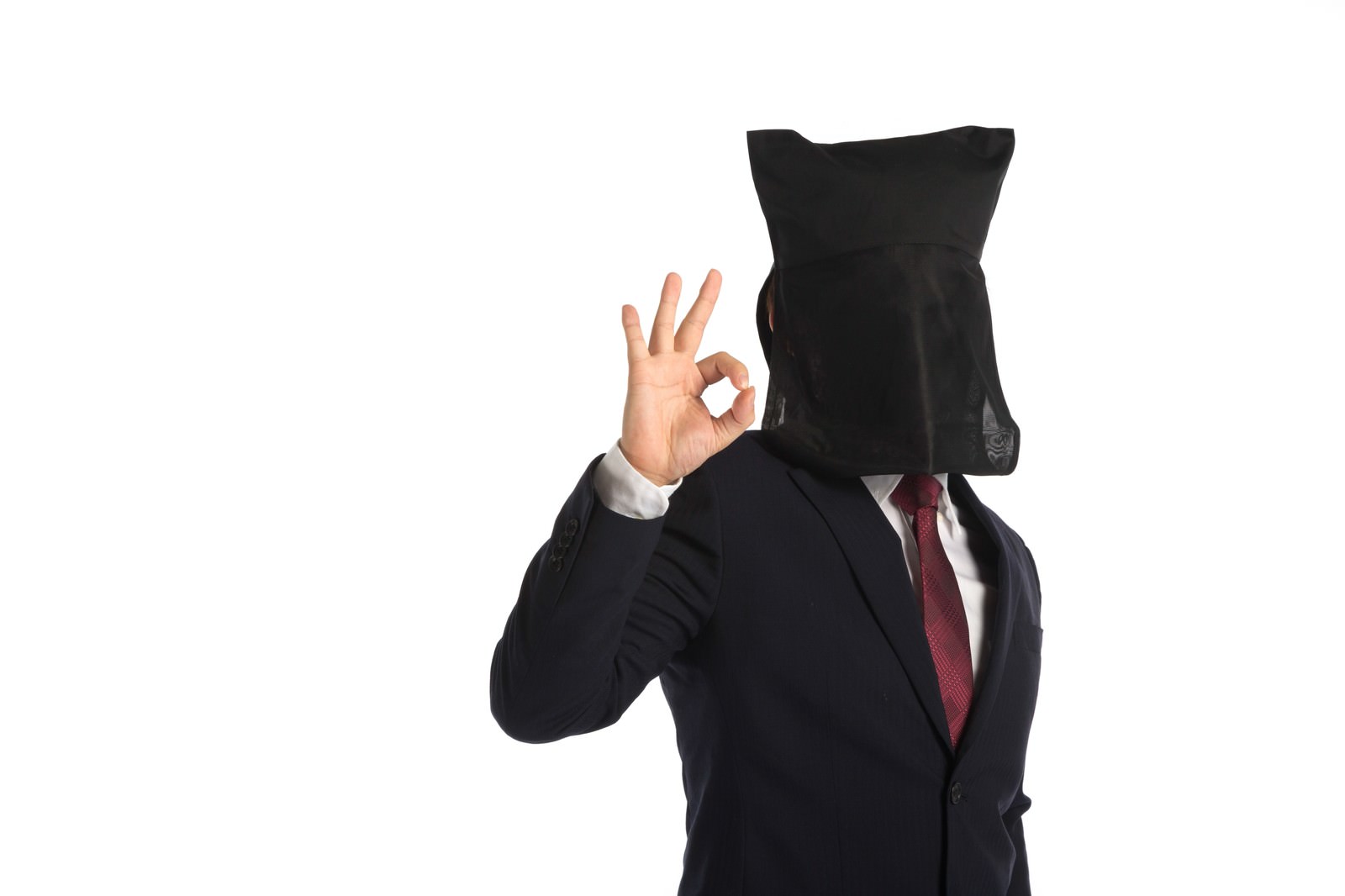 黒い袋を被った匿名のスーツ姿の男性がOKサインを出している