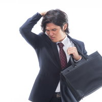 体臭を気にして困る外回り中のスーツ姿の会社員の写真