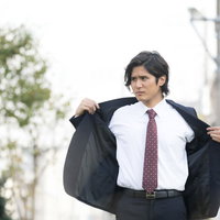 脇汗を気にして外出中に上着を脱ぐサラリーマンの写真