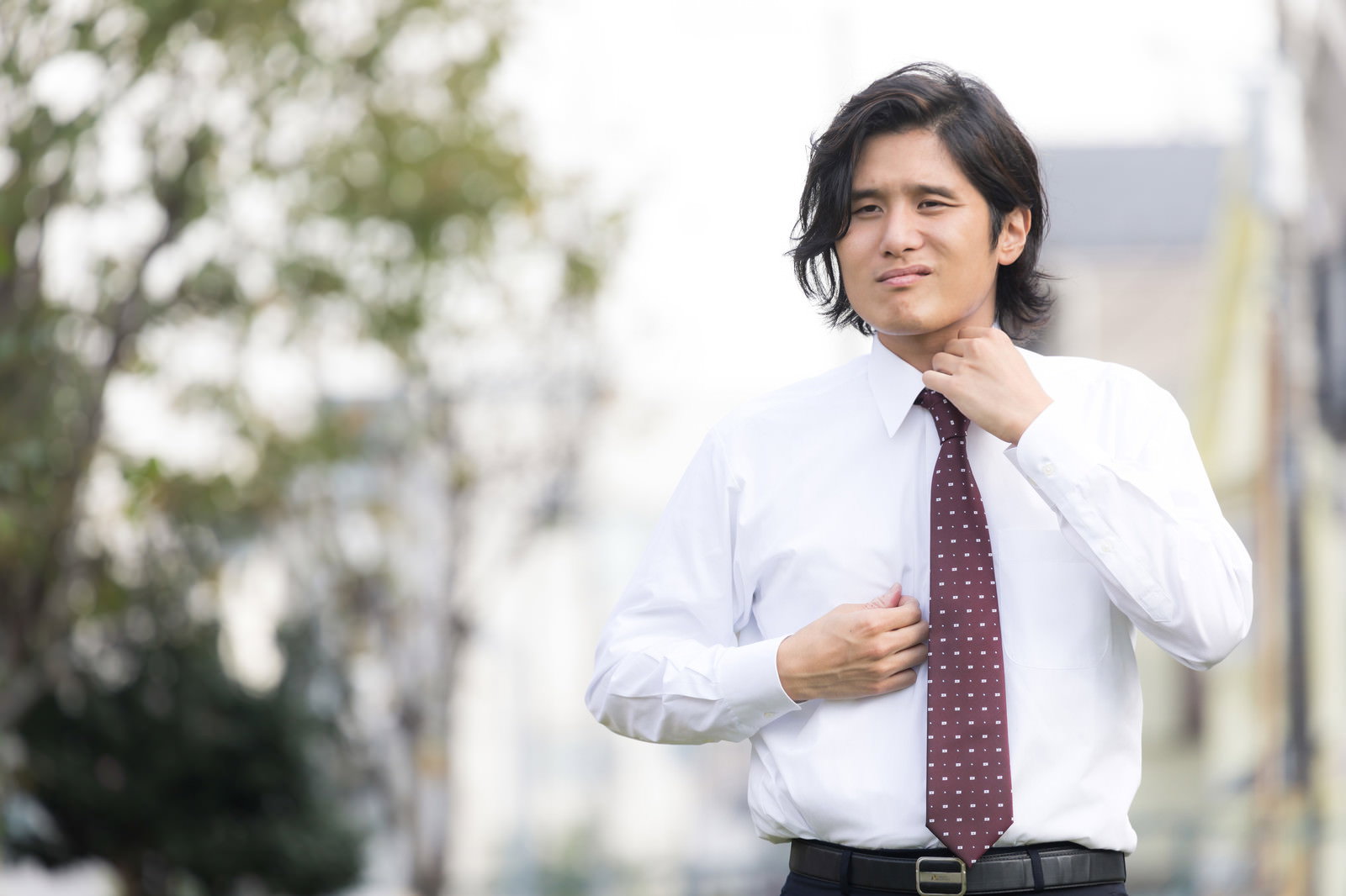 暑さで汗をかいているワイシャツ姿の会社員男性［モデル：竹田匡宏］