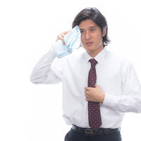 暑さに息切れしながら汗をかく、くさいと困っているビジネスマンの男性の写真
