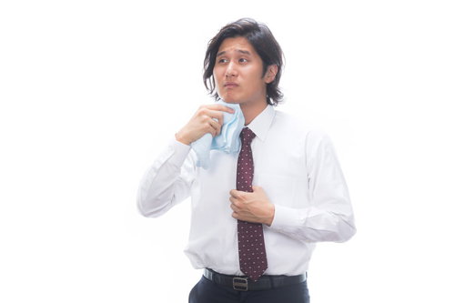 タオルで汗を拭く男性サラリーマンの体臭対策