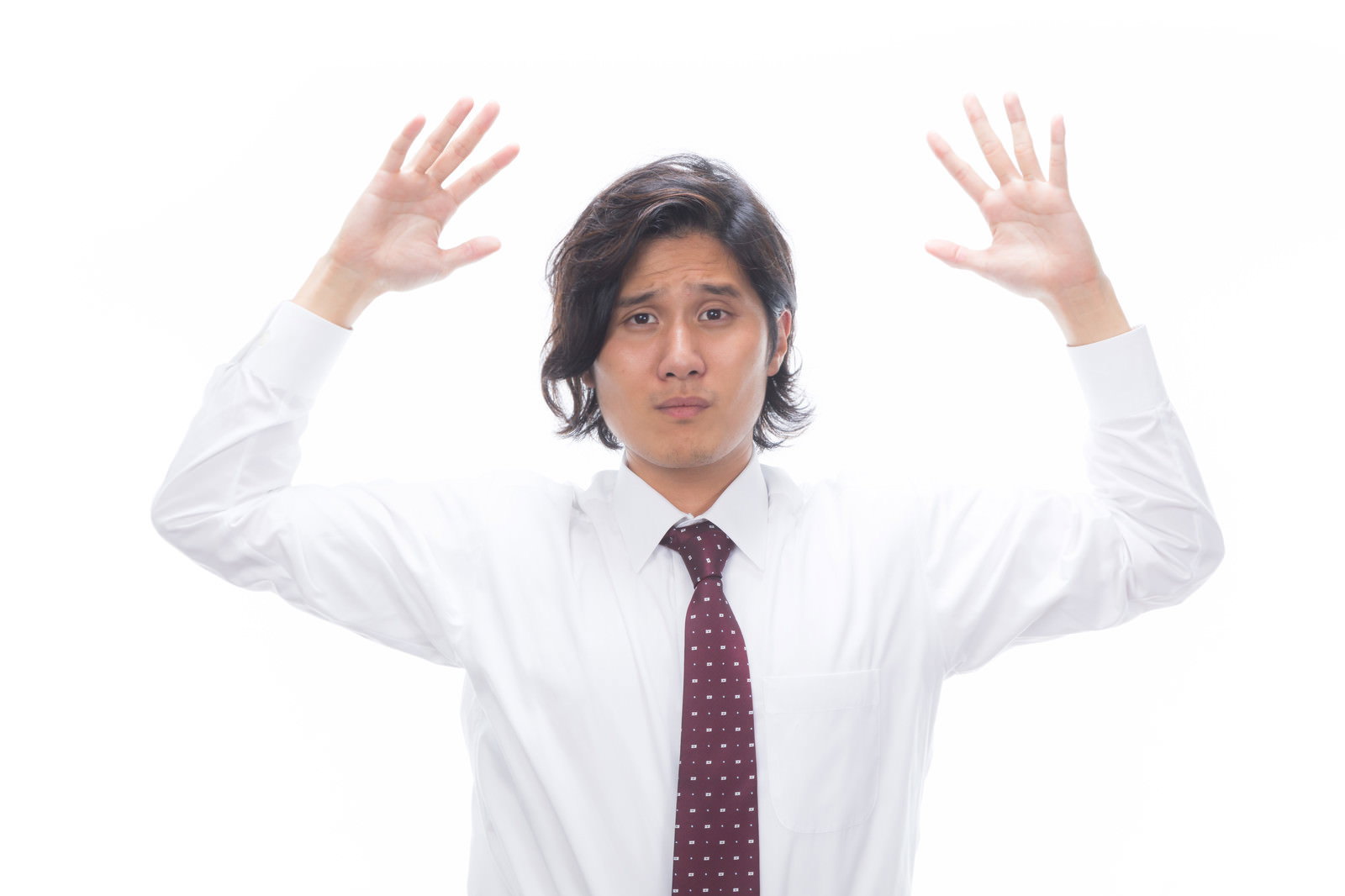 白いワイシャツと濃紫色ネクタイを着た男性が両腕を上げて困った表情［モデル：竹田匡宏］