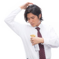 ワキのにおいを嗅ぐ男性会社員、体臭やワキガの悩みの写真
