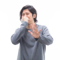 耐え難い悪臭で顔を背けてストップポーズをとる男性の写真