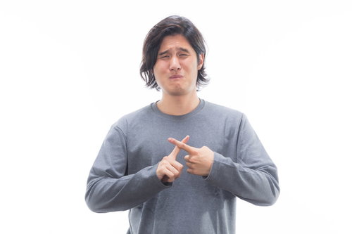 ダメダメすぎて梅干し顔、グレーのニットで指差す男性