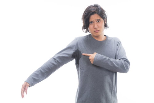 脇汗が気になるグレートレーナー姿の男性、汗染みと体臭の悩み