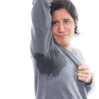 脇汗びっしょりで思わずしゃくれる男性、ワキガや体臭に困惑の写真